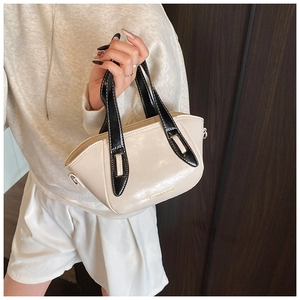Detail of a beige and black leather bucket bag with golden Fashion & Bags text accent