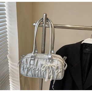 Detail of silver pleated bowling bag featuring pearl lace bow and metallic handles
