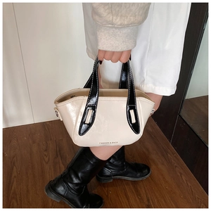 Detail of minimalist cream bucket bag with black handles and FASHION & BAGS logo