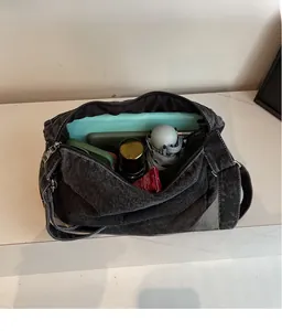 Macro view of black denim tote bag interior showing large capacity and daily storage space
