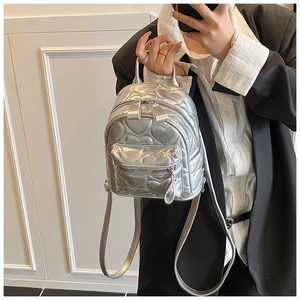Detail of silver heart-quilted PU leather texture and zipper on the mini backpack