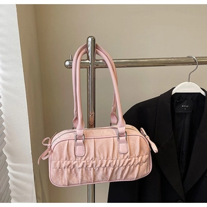Detailed macro view of pink pleated handbag texture with silver metal buckles and bow details
