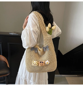 Détail du sac cabas en paille tissé main avec nœuds vichy et breloques en peluche