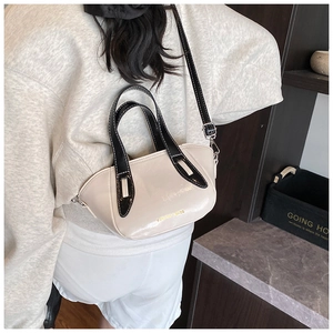 Detail of cream glossy leather bucket bag with black handles and fashion gold lettering