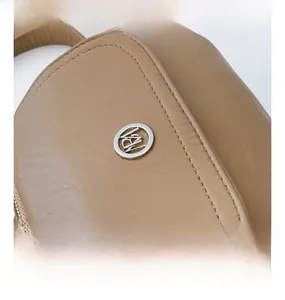 Detailed macro view of litchi textured camel leather crossbody bag with silver RN logo