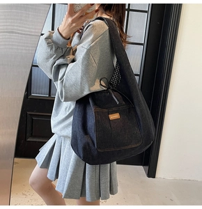 Detail of navy denim tote bag with drawstring closure and stylish checkered lining