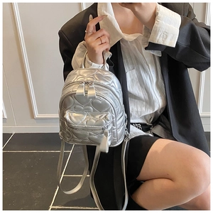 Detailed view of silver mini backpack featuring luxury heart quilted pattern and metal zip