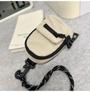 Detailed view of mini nylon crossbody bag for earphones with industrial zip and strap