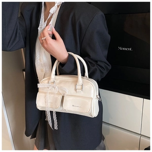 Detail of cream white PU leather handbag featuring lace bow and silver hardware accents