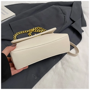 Detail view of the square bag bottom and stitching with decorative gold chain handle