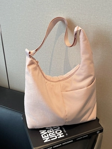 Minimalist light pink nylon crescent tote bag with adjustable strap and zipper closure