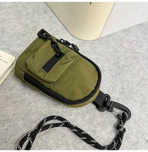 Close-up of military green mini functional crossbody pouch with black carabiner and rope