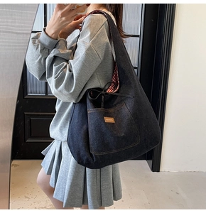 Mirror selfie showing large denim tote bag with striped lining and drawstring detail