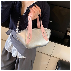 Detail view of silver metallic PU handbag with pink handles and FASHION lettering