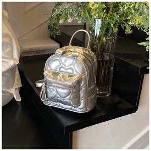 Silver mini quilted backpack featuring heart stitching and polished faux leather finish
