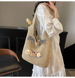 Sac fourre-tout en paille avec oursons et nœud à carreaux porté par un mannequin