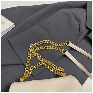 Detail of beige flap bag featuring a gold chunky chain and leather shoulder strap