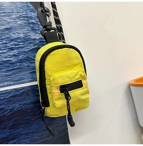 Macro view of bright yellow mini backpack keychain made from durable waterproof nylon material