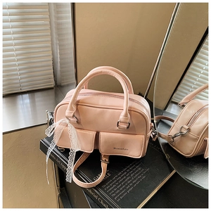 Detailed close-up of pink PU leather handbag with side lace ribbon and front pockets