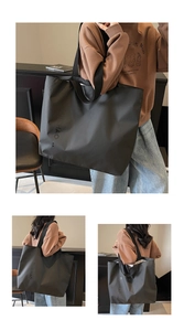 Detail shot of a black oversized nylon tote bag with white lettering for daily commute