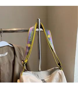 Detail of multi-color adjustable letter print shoulder strap on khaki crossbody bag