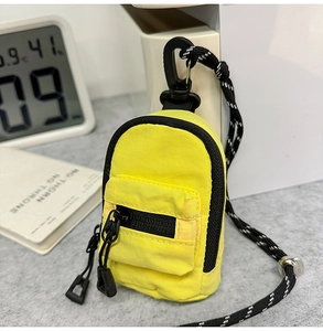 Detail view of mini yellow backpack pouch with black zipper and adjustable neck strap