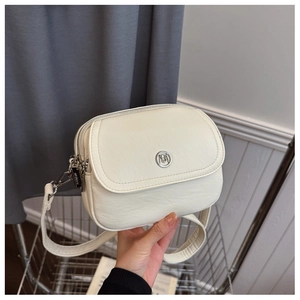 Detail of cream PU leather crossbody bag with MUBAO logo and adjustable strap