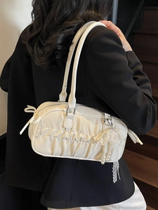 White ruched satin boston bag with bow detail and lace pearl charm carried by model