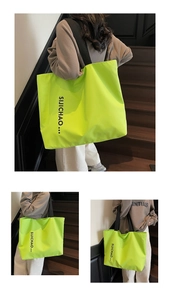 Detailed view of neon green tote bag with black letter print and wide fabric straps