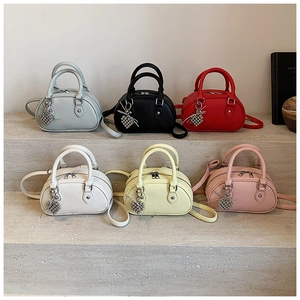 Détail de mini sacs Boston en six couleurs avec texture litchi et breloque en cœur
