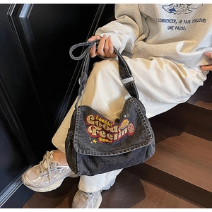 Macro shot of black washed denim crossbody bag with colorful 'Lookin Good' letter embroidery