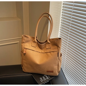 Detailed view of camel canvas tote bag showing front zipper pocket and KFBAG leather logo
