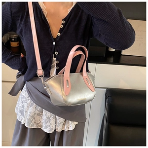 Detail of silver matte bag with contrast pink handles and fashion lettering text