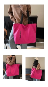 Macro detail of large rose red tote bag with black straps and letter print for women