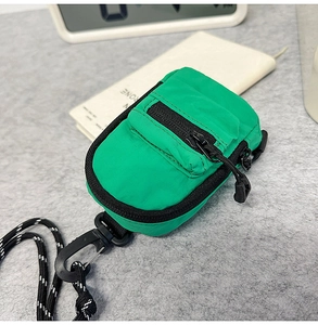 Mini green nylon crossbody pouch with black zipper detail and neck lanyard strap