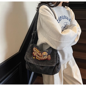 Detailed embroidery on vintage denim crossbody bag featuring colorful star patterns