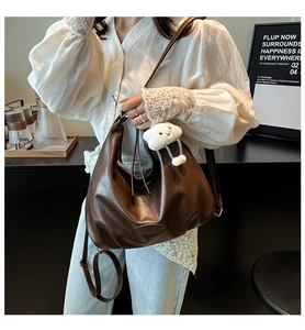 Détail du sac croissant en cuir marron foncé avec grain litchi et bijou nuage
