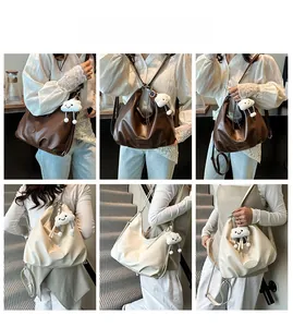 Détail de la texture en cuir PU souple et logo rond embossé sur les grands sacs cabas