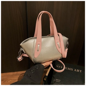 Detail of silver cracked leather handbag with pink handles and detachable strap