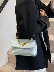 Blue glossy chain shoulder bag with gold hardware and pearl charm on a model