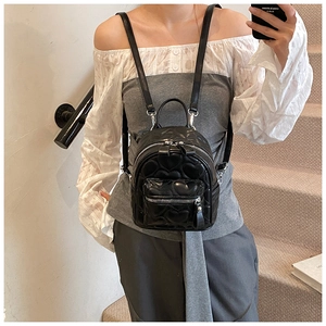 Close-up of heart-quilted black PU leather mini backpack with detailed stitching
