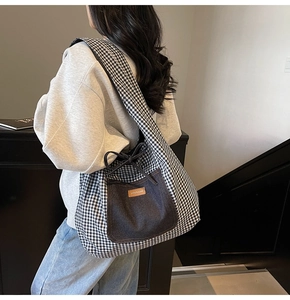 Detail of canvas tote bag featuring black and white check pattern and denim pocket detail
