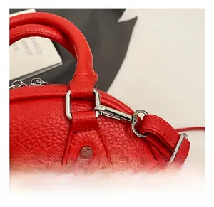Détail du sac à main rouge avec cuir grainé et mousqueton en métal argenté poli sur l'anneau