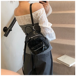 Close-up of quilted black leather mini backpack with elegant diamond pattern and zippers