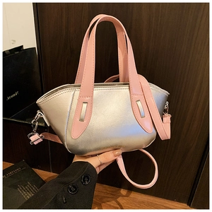 Detail of silver metallic crossbody bag with contrast pink handles and fashion lettering