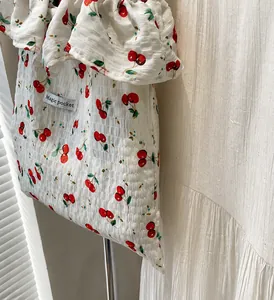 Detail of white seersucker tote bag with red cherry print and ruffled edge trimming