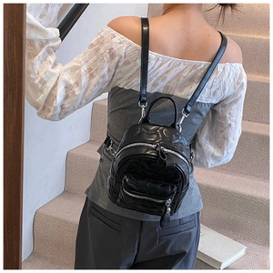 Chic black mini backpack with heart quilted PU leather shown on person for scale