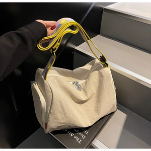 Detail of beige nylon crossbody bag featuring colorful jacquard strap and silver zippers