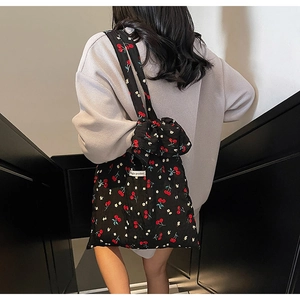 Detail of floral canvas tote bag with cherry print and wide shoulder strap