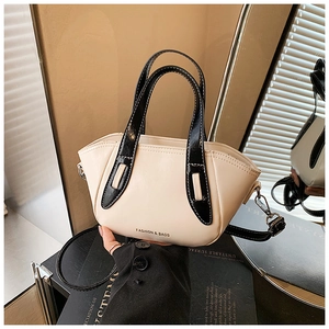 Close-up of beige leather bucket bag with black handles and fashion text detail